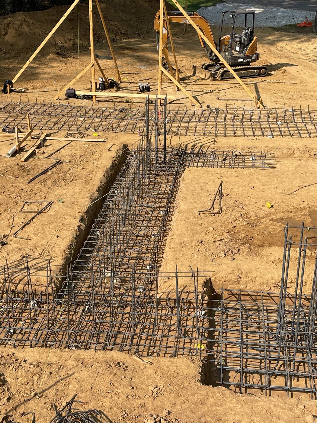 Excavated footing trenches with tied rebar cages and reinforcing set in place for a commercial foundation